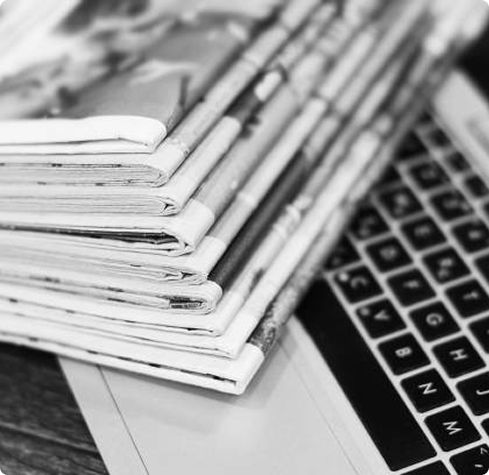 Stack of newspapers on a laptop keyboard